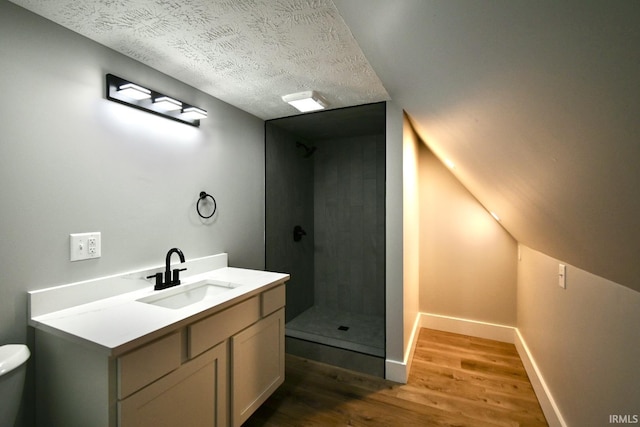 bathroom with walk in shower, wood-type flooring, a textured ceiling, toilet, and vanity