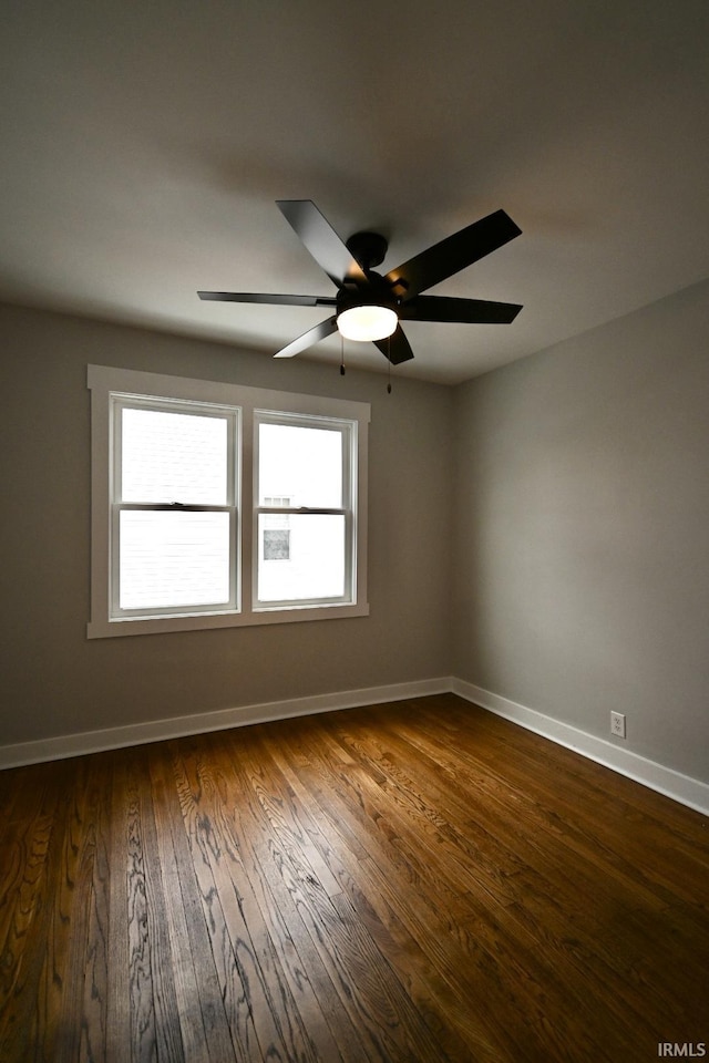 empty room featuring ceiling fan and dark wood-type flooring