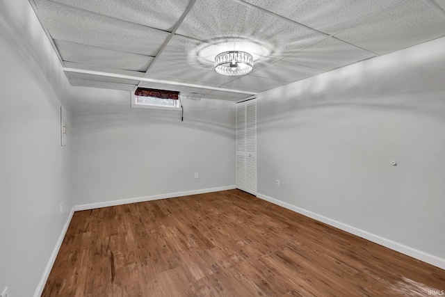 empty room featuring wood-type flooring and a drop ceiling