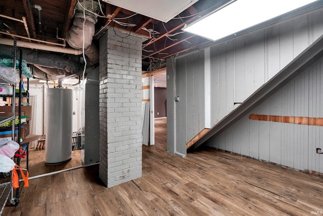 basement featuring wood-type flooring and water heater