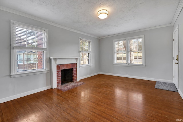 unfurnished living room featuring wood-type flooring, a textured ceiling, a brick fireplace, and ornamental molding