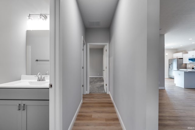 hall featuring light hardwood / wood-style flooring and sink