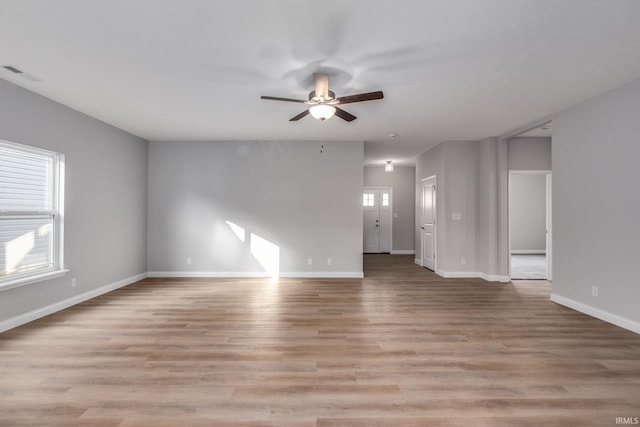 unfurnished room with plenty of natural light, ceiling fan, and light wood-type flooring