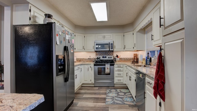 kitchen featuring white cabinets, a textured ceiling, backsplash, and stainless steel appliances