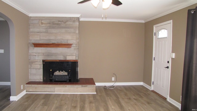 interior space featuring hardwood / wood-style floors, crown molding, a fireplace, and ceiling fan