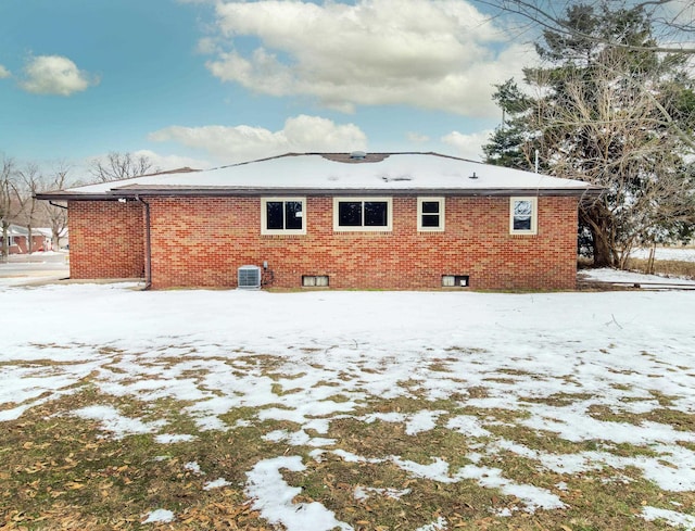 snow covered back of property with cooling unit