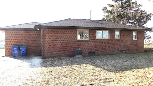 view of side of home with a yard and central AC