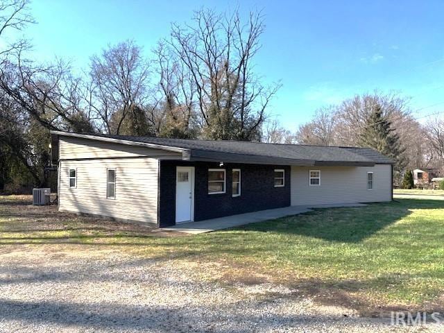 back of property with a lawn and central AC