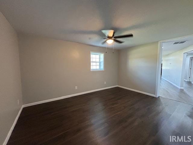 spare room with ceiling fan and dark wood-type flooring