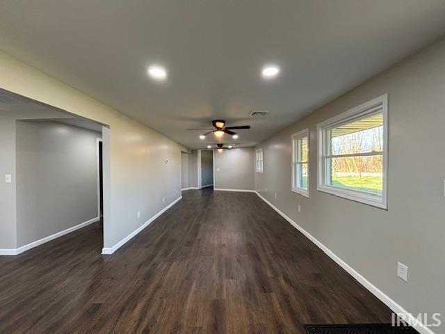 unfurnished living room with dark hardwood / wood-style floors and ceiling fan