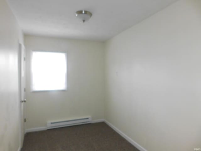 carpeted empty room featuring a baseboard radiator