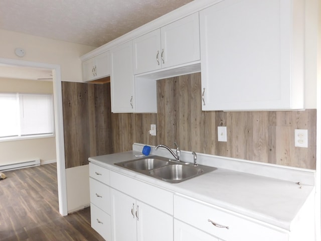 kitchen with white cabinetry, sink, baseboard heating, dark hardwood / wood-style floors, and a textured ceiling