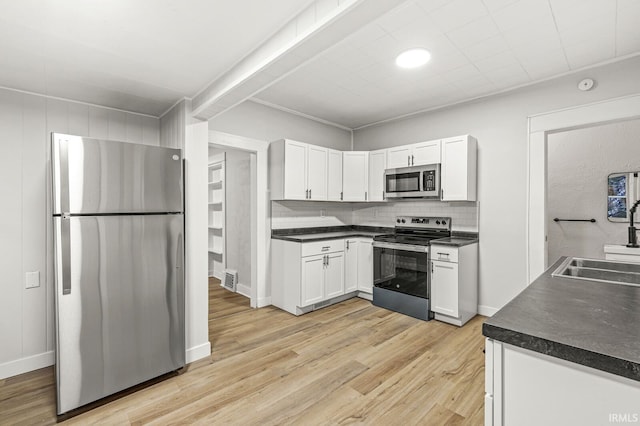 kitchen featuring white cabinets, sink, decorative backsplash, light hardwood / wood-style floors, and stainless steel appliances