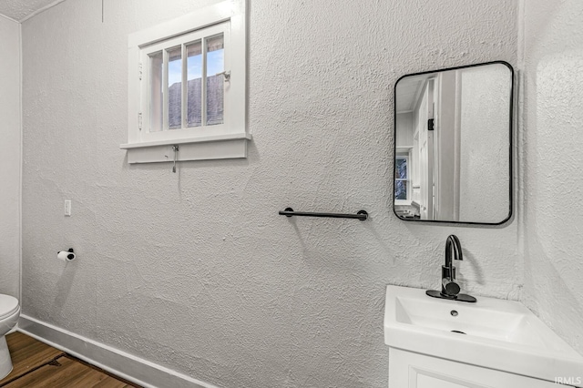 bathroom with hardwood / wood-style floors, toilet, and sink