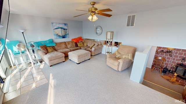 living room featuring ceiling fan, a wood stove, and carpet floors