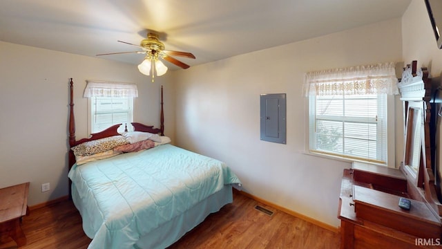 bedroom featuring ceiling fan, dark wood-type flooring, and electric panel