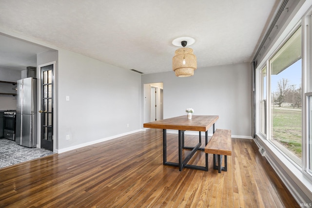 dining space featuring a healthy amount of sunlight and wood-type flooring