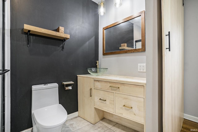 bathroom featuring tile patterned flooring, vanity, and toilet