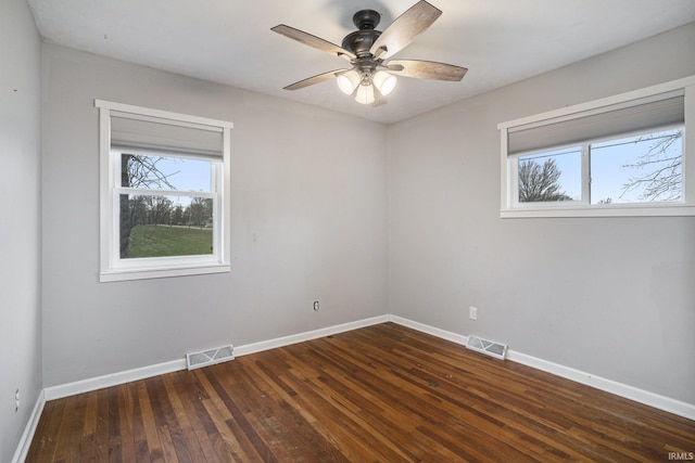 empty room with ceiling fan and dark hardwood / wood-style floors