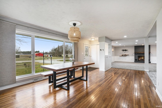 dining area featuring wood-type flooring and a textured ceiling