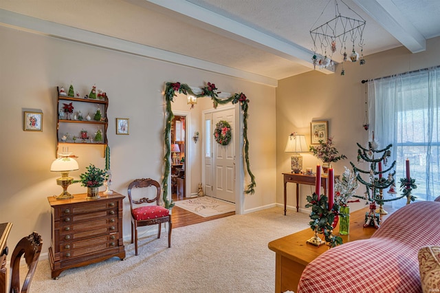 living area featuring beam ceiling, carpet floors, a textured ceiling, and an inviting chandelier