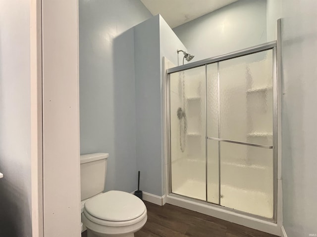 bathroom with wood-type flooring, toilet, and walk in shower