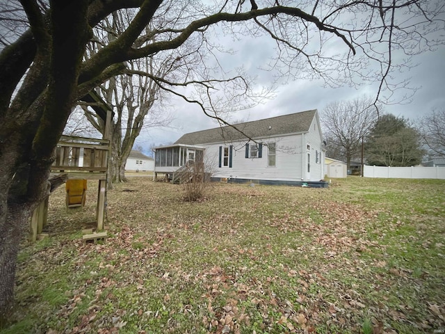 back of property featuring a sunroom and a yard