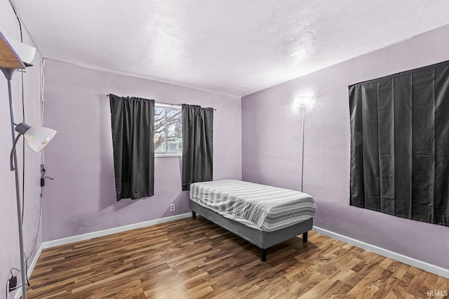 bedroom with dark hardwood / wood-style flooring