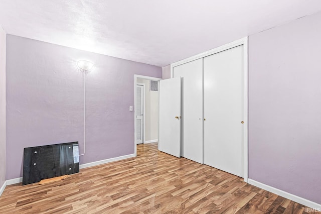 unfurnished bedroom featuring a closet and light hardwood / wood-style floors