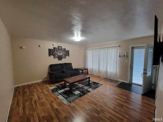 unfurnished living room featuring a textured ceiling and dark hardwood / wood-style floors