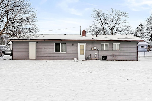 view of snow covered back of property