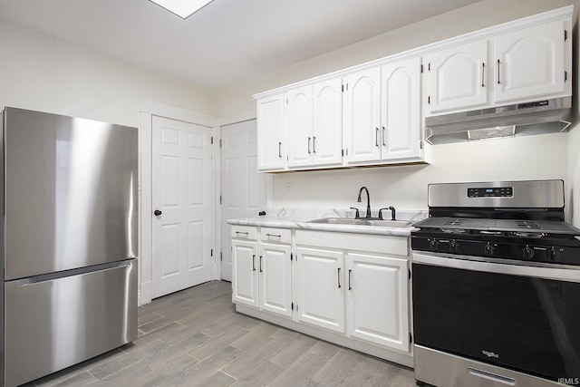 kitchen featuring sink, white cabinetry, stainless steel appliances, and light hardwood / wood-style flooring