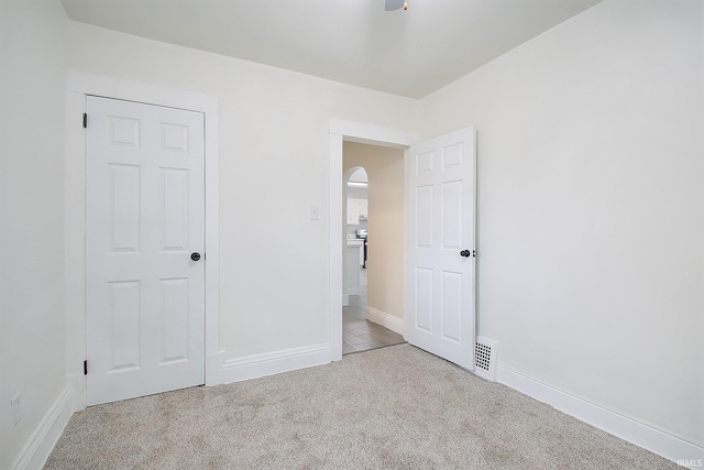 unfurnished bedroom featuring light colored carpet and a closet