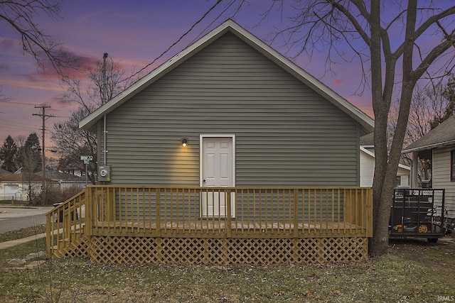 property exterior at dusk featuring a deck