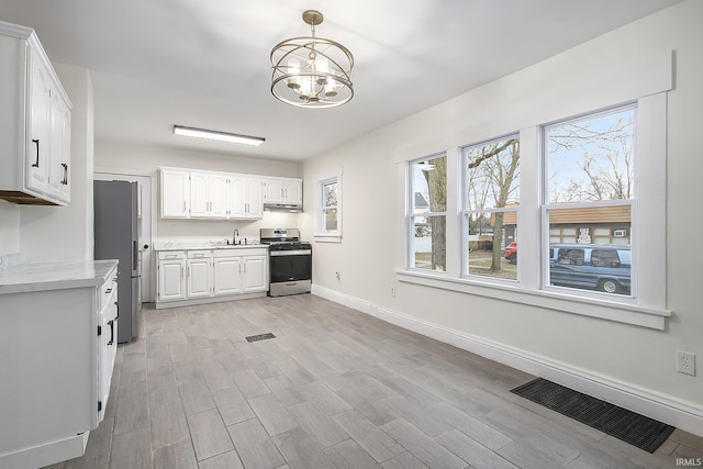 kitchen featuring sink, hanging light fixtures, a chandelier, white cabinets, and appliances with stainless steel finishes