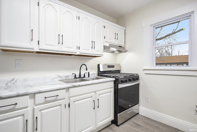 kitchen with light wood-type flooring, white cabinetry, sink, and stainless steel range with gas stovetop