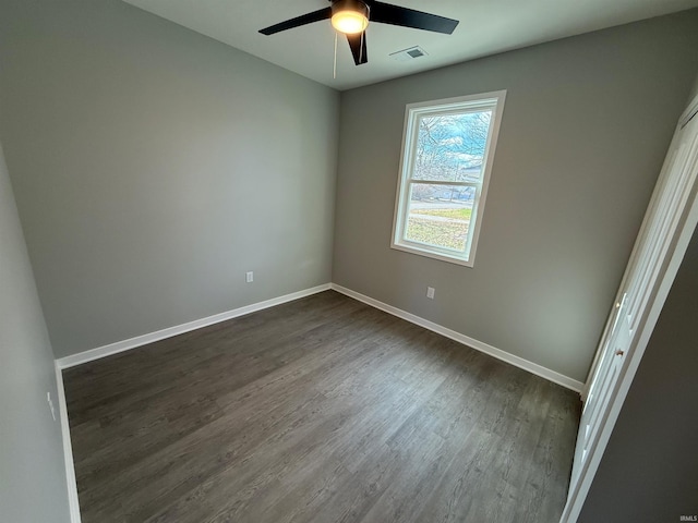 empty room featuring ceiling fan and dark hardwood / wood-style flooring