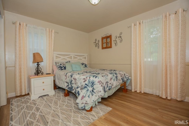 bedroom with light wood-style floors and baseboards