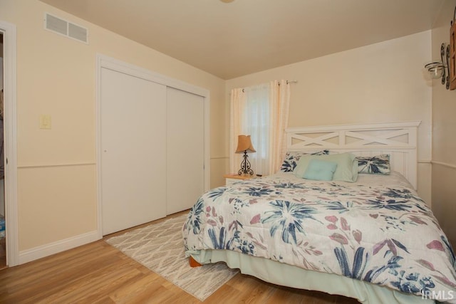 bedroom featuring a closet, wood finished floors, and visible vents