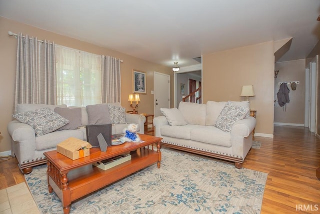 living room featuring stairway, wood finished floors, and baseboards