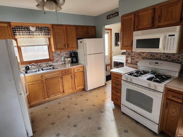 kitchen with white appliances, washer / clothes dryer, tasteful backsplash, and sink