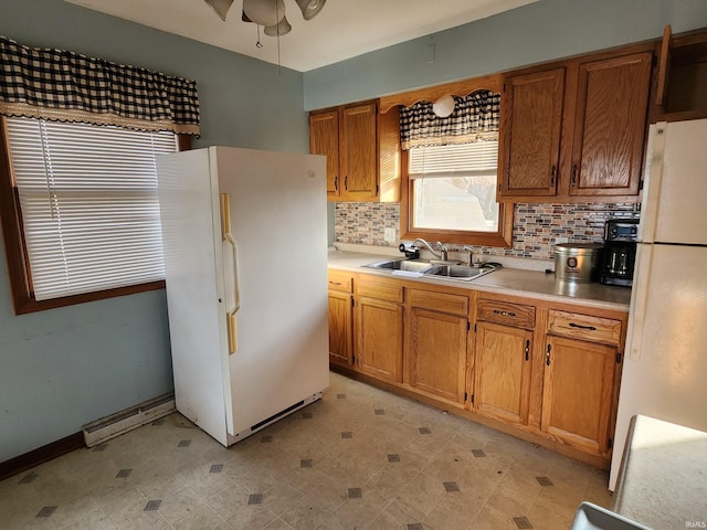 kitchen featuring white refrigerator, sink, and tasteful backsplash