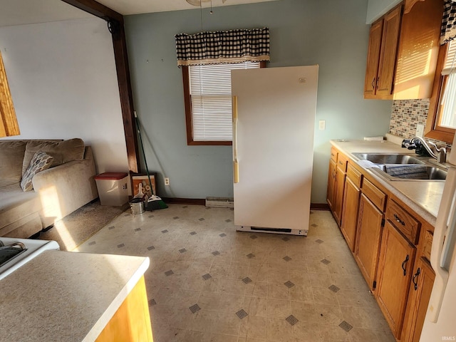 kitchen featuring tasteful backsplash, sink, and white fridge