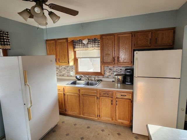 kitchen with white refrigerator, backsplash, and sink