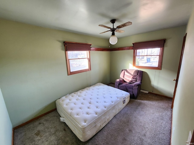 carpeted bedroom with ceiling fan and baseboard heating