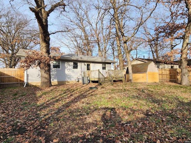 back of property featuring a shed and a deck