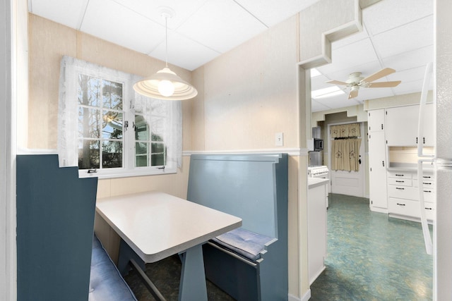 dining room with breakfast area, ceiling fan, and a paneled ceiling