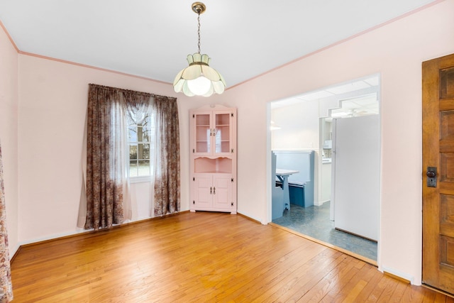 unfurnished dining area featuring wood-type flooring and ornamental molding