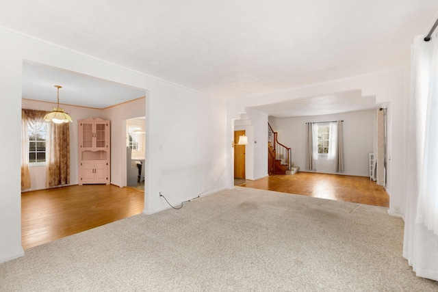 unfurnished living room featuring light colored carpet and radiator