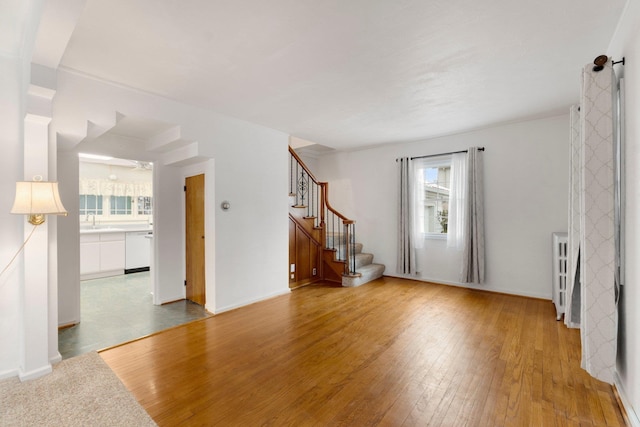 unfurnished room with plenty of natural light, sink, and light hardwood / wood-style flooring